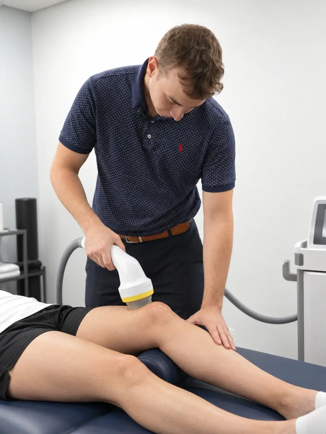 Dr. Brian Donovan performing SoftWave therapy on a patient's knee