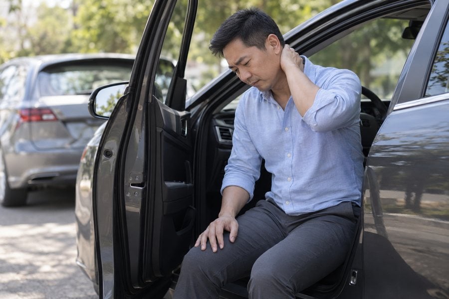 Man with whiplash after a car collision, evaluated by Dr. Brian Donovan at Nuro Chiropractic in Brooklyn