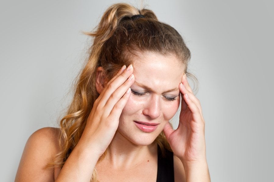 Woman with a headache, evaluated by Dr. Brian Donovan at Nuro Chiropractic in Brooklyn