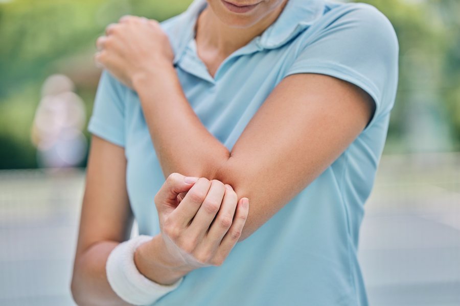 Woman in Brooklyn with elbow pain, evaluated by Dr. Brian Donovan at Nuro Chiropractic