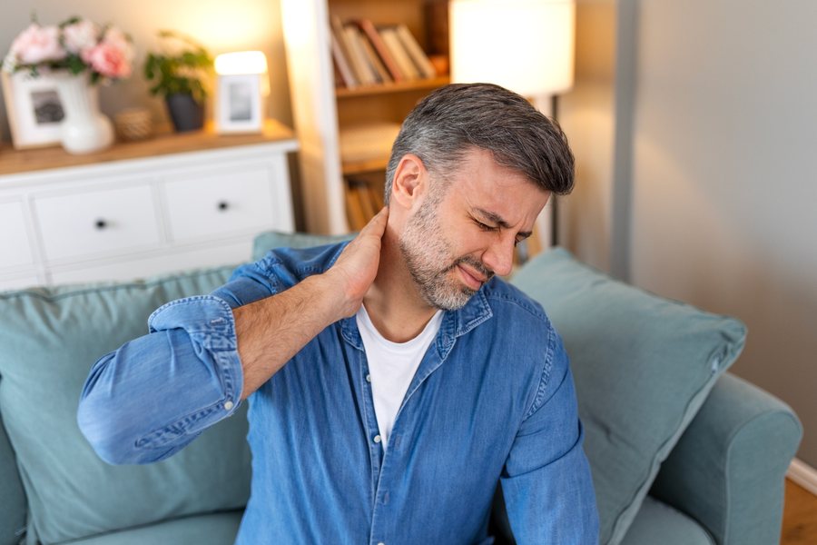Man with pinched nerve pain in his neck and shoulder, evaluated by Dr. Brian Donovan at Nuro Chiropractic in Brooklyn